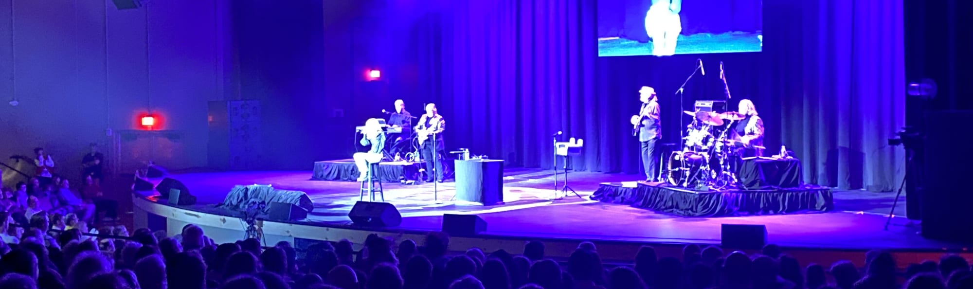 signer on stage in chair washed out by the lights Raleigh